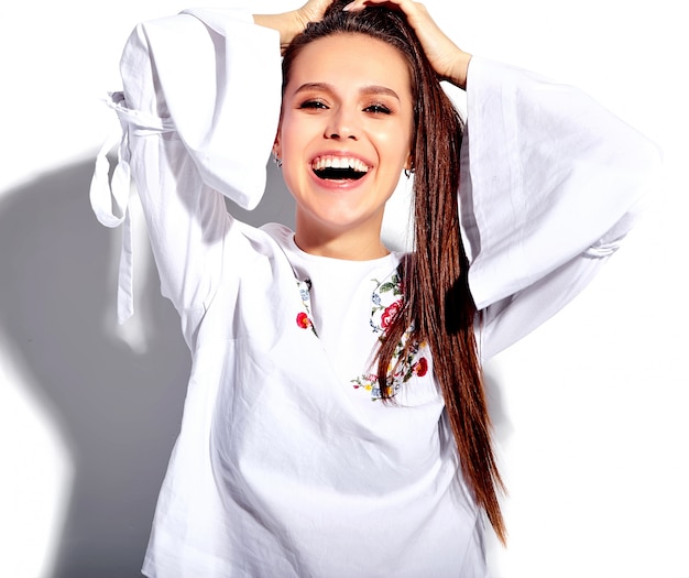 Portrait de la belle femme brune souriante caucasienne modèle en blouse blanche et élégant jeans bleu d'été avec des fleurs imprimer