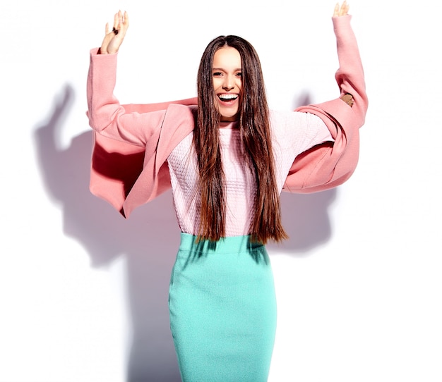 Portrait de la belle femme brune souriante caucasienne modèle en pardessus rose vif et jupe bleue élégante d'été