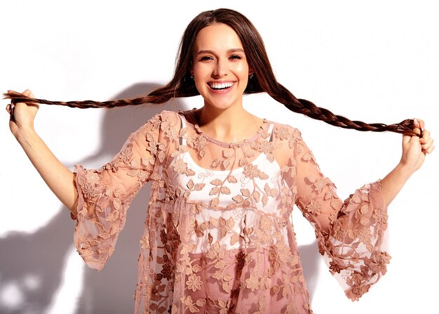 Portrait de la belle femme brune souriante caucasienne modèle en vêtements élégants d'été rose vif isolé sur fond blanc.