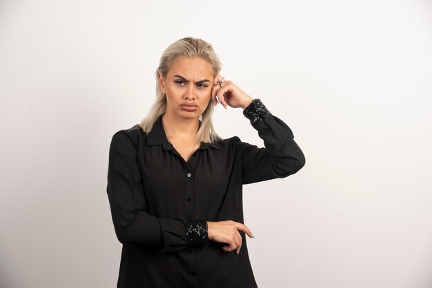 Portrait de la belle femme en chemise noire posant sur fond blanc. Photo de haute qualité