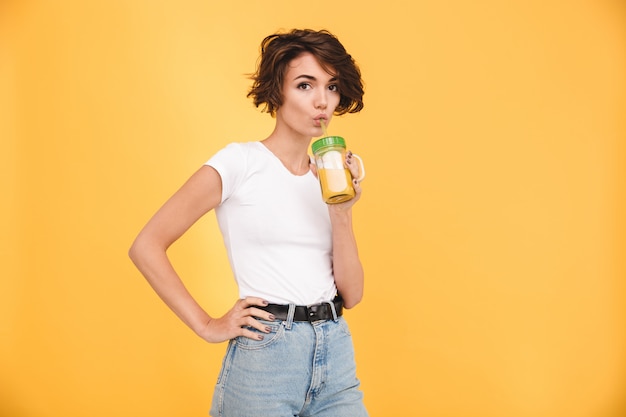 Photo gratuite portrait d'une belle femme décontractée, boire du jus d'orange