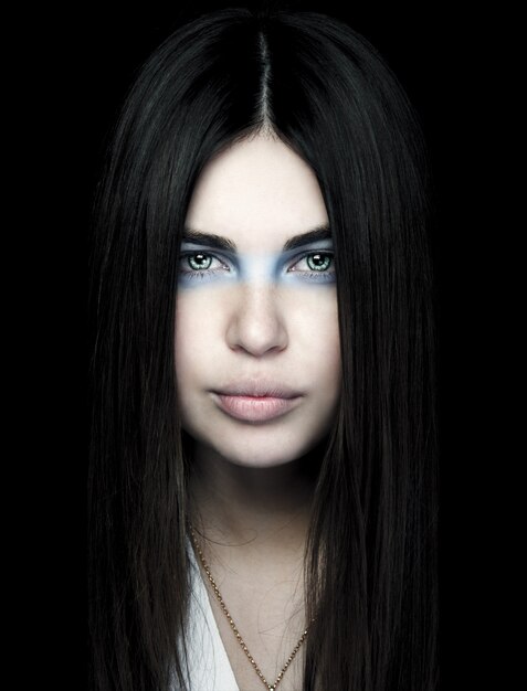 Portrait de la belle femme avec du maquillage bleu autour des yeux