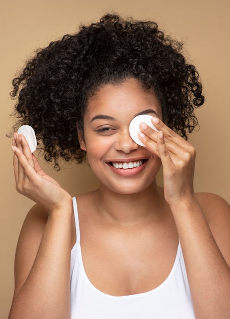 Portrait d'une belle femme enlevant son maquillage avec des garnitures