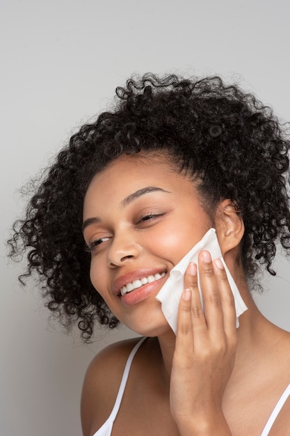 Portrait d'une belle femme enlevant son maquillage avec un tissu