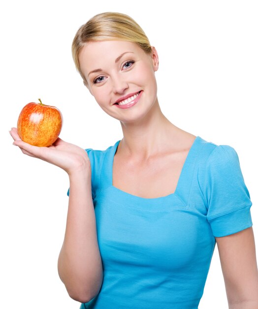 Portrait d'une belle femme heureuse avec une pomme rouge - isolé sur blanc