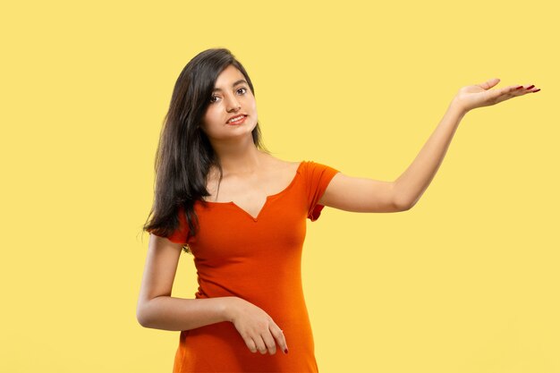 Portrait de belle femme isolée sur fond de studio jaune