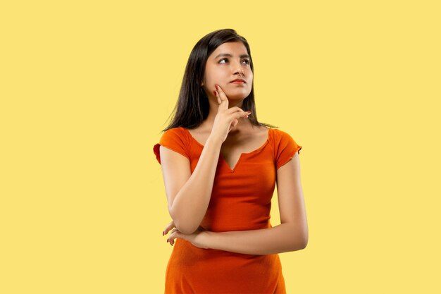 Portrait de belle femme isolée sur fond de studio jaune