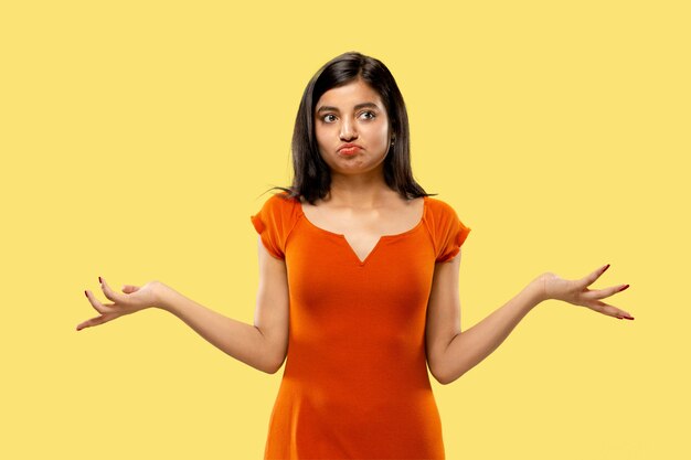 Portrait de belle femme isolée sur fond de studio jaune