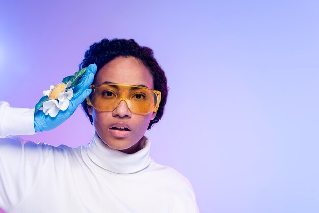 Portrait de la belle femme avec des lunettes de sécurité et des gants floraux