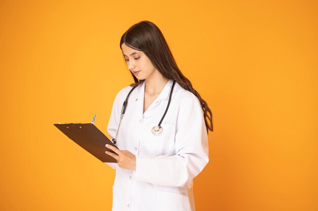 Portrait d'une belle femme mature médecin en blouse de laboratoire tenant un document et regardant la caméra