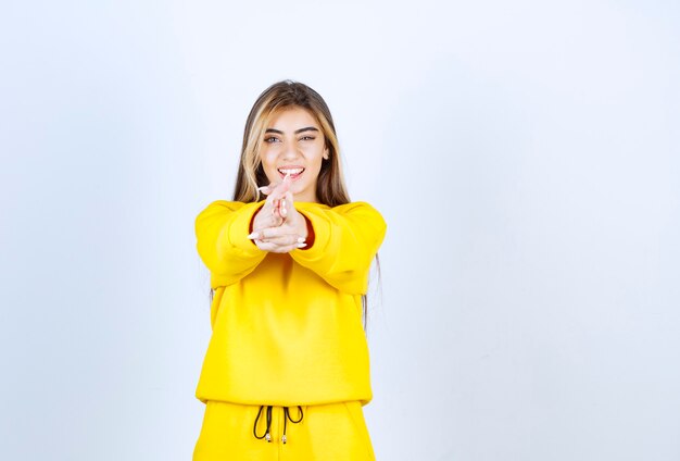 Portrait de belle femme modèle debout et posant en t-shirt jaune