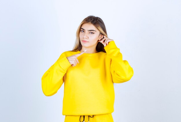 Portrait de belle femme modèle debout et posant en t-shirt jaune