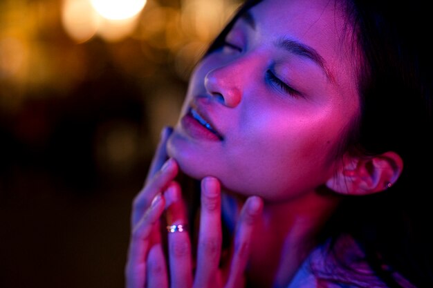 Portrait de belle femme la nuit dans les lumières de la ville