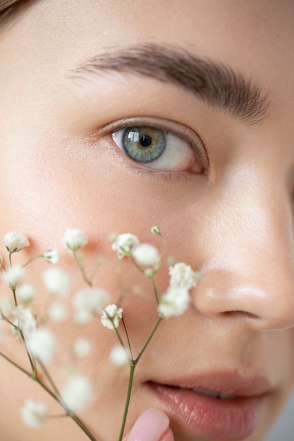 Photo gratuite portrait de belle femme à la peau claire posant avec des fleurs de souffle de bébé