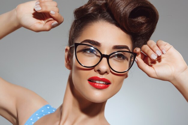 Portrait de la belle femme pin up portant des lunettes