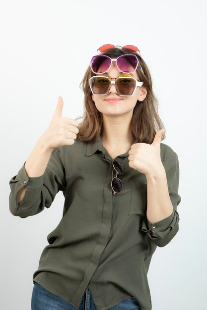 Portrait d'une belle femme portant de nombreuses lunettes de soleil sur blanc. Photo de haute qualité