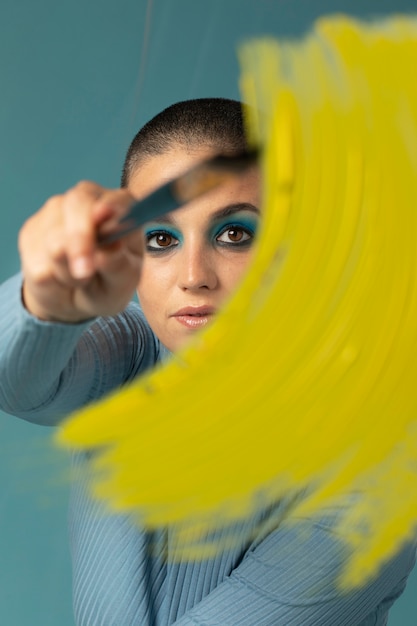 Photo gratuite portrait de belle femme posant dans un col roulé avec coup de pinceau jaune