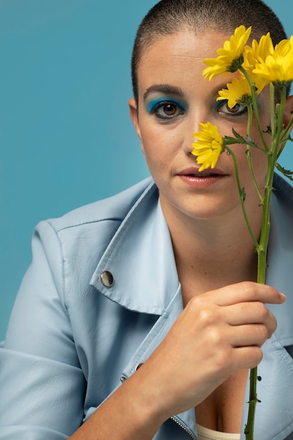 Portrait de belle femme posant dans une veste bleue avec des fleurs