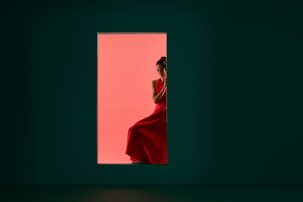 Portrait de belle femme posant avec une robe rouge fluide