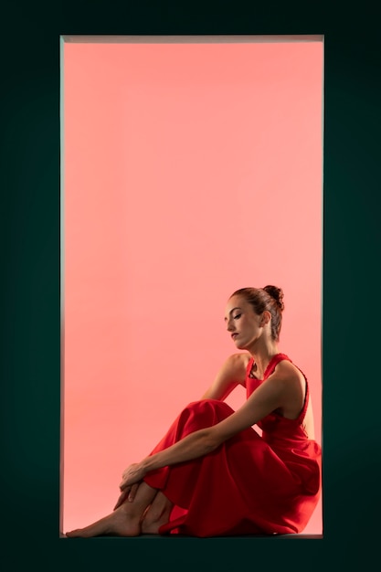 Portrait de belle femme posant avec une robe rouge fluide