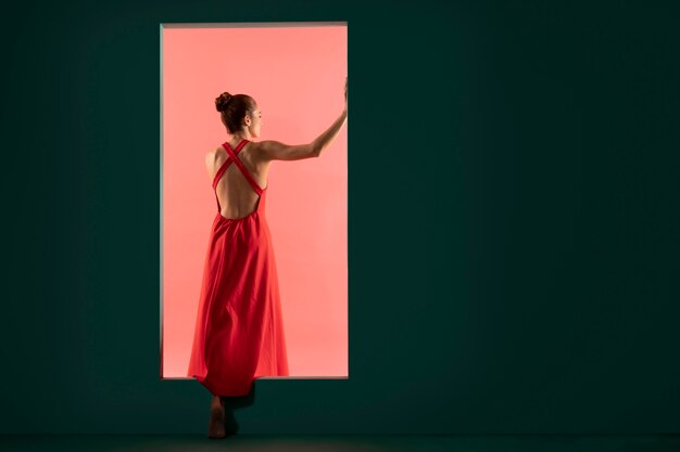 Portrait de belle femme posant avec une robe rouge fluide