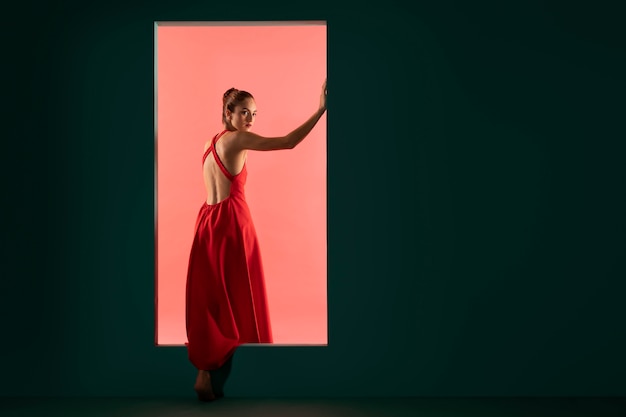 Portrait de belle femme posant avec une robe rouge fluide