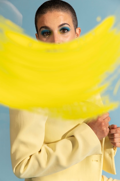 Portrait de belle femme posant avec une veste jaune et un coup de pinceau
