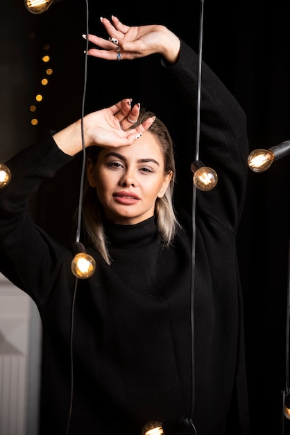 Portrait de la belle femme en pull noir debout et posant