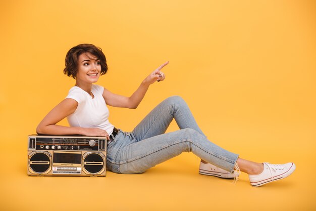 Portrait d'une belle femme souriante assise avec tourne-disque