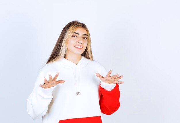 Portrait d'une belle femme en sweat à capuche chaud debout et regardant la caméra