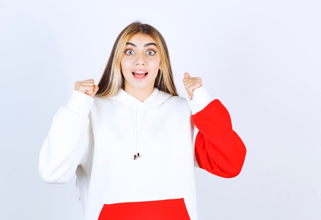 Portrait d'une belle femme en sweat à capuche chaud debout et se réjouissant