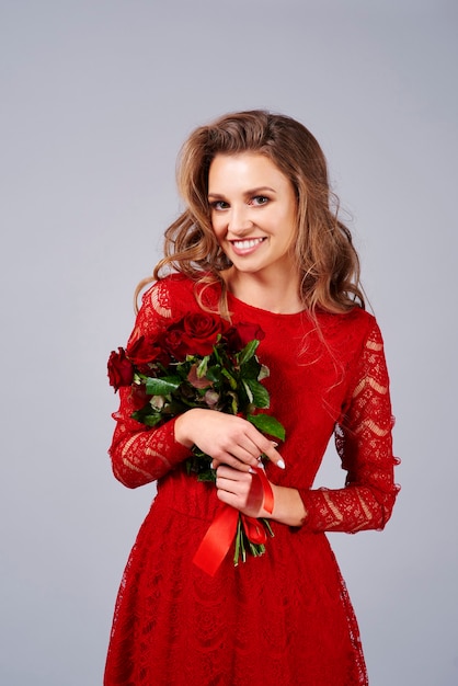 Portrait de belle femme tenant un bouquet de roses rouges