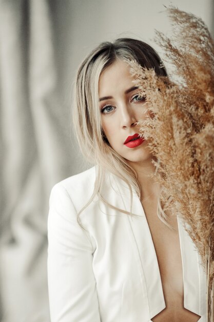 Portrait de belle fille dans une veste blanche et avec des lèvres rouges