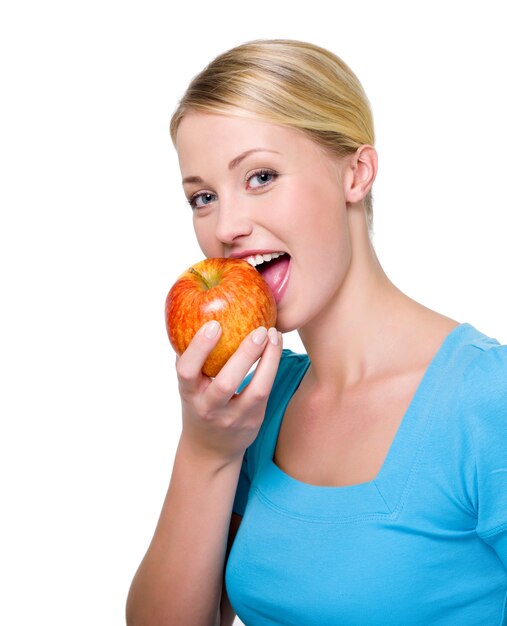 Portrait d'une belle fille heureuse mordre la pomme rouge fraîche. Copier l'espace