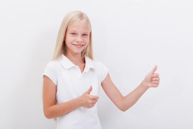 Portrait d'une belle fille montrant les pouces vers le haut