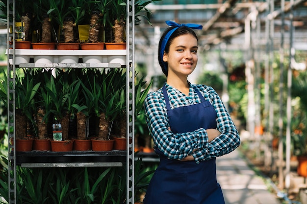 Portrait d'une belle jardinière féminine debout dans une serre