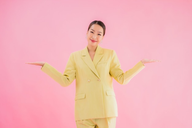 Portrait belle jeune femme d'affaires asiatique sourire en action sur la couleur rose