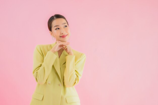 Portrait belle jeune femme d'affaires asiatique sourire en action sur la couleur rose