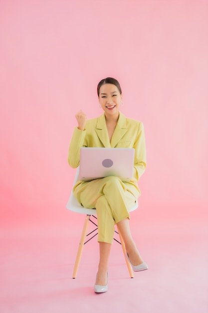 Portrait belle jeune femme d'affaires asiatique utiliser un ordinateur portable sur la couleur