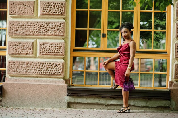 Portrait d'une belle jeune femme africaine naturelle aux cheveux afro Modèle noir en robe de soie rouge