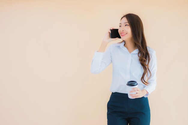 Portrait belle jeune femme asiatique d'affaires avec téléphone mobile intelligent et tasse de café