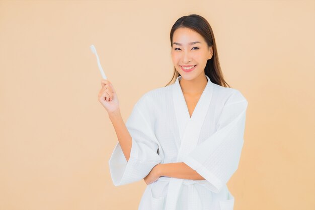 Portrait belle jeune femme asiatique avec brosse à dents sur beige