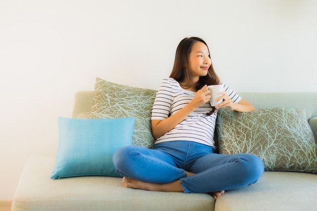 Portrait Belle Jeune Femme Asiatique Sur Le Canapé Avec Une Tasse De Café