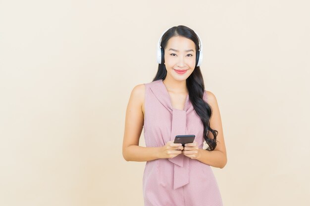 Portrait belle jeune femme asiatique avec casque et smartphone pour écouter de la musique