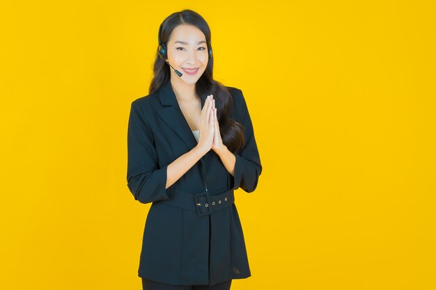 Portrait belle jeune femme asiatique avec centre d'appels centre de service client sur jaune jaune