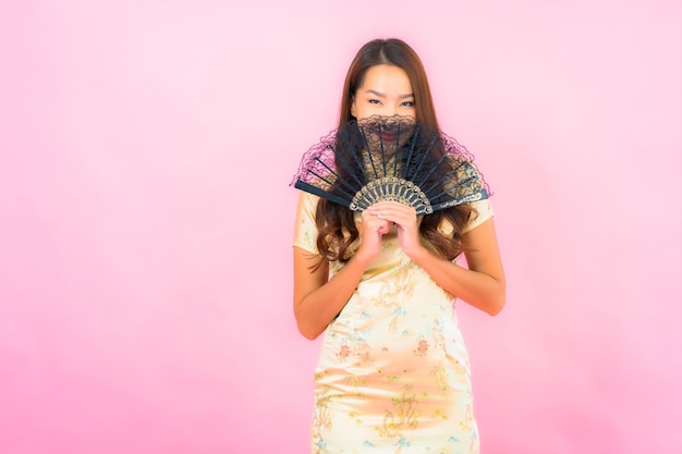 Portrait belle jeune femme asiatique avec concept de nouvel an chinois et ventilateur sur mur de couleur