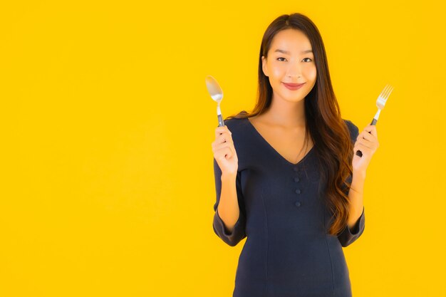 Portrait belle jeune femme asiatique avec cuillère et fourchette