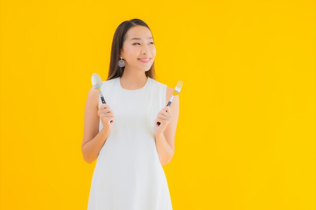 Portrait belle jeune femme asiatique avec cuillère fourchette