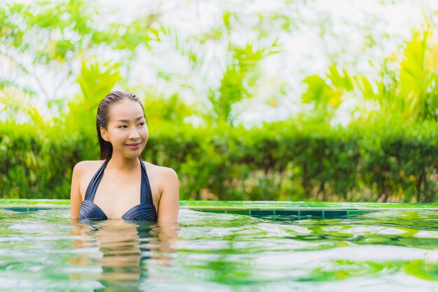 Portrait belle jeune femme asiatique dans la piscine autour de l&#39;hôtel et la station