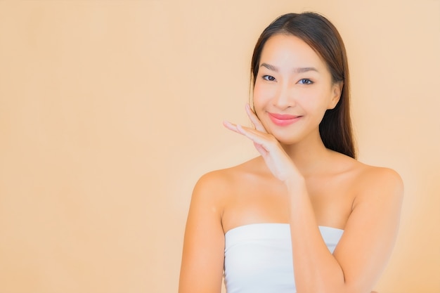Portrait belle jeune femme asiatique dans un spa avec maquillage naturel sur beige